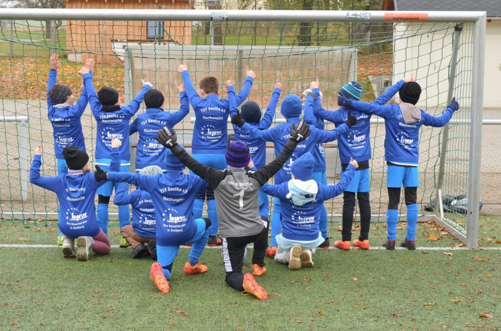 Gruppenfoto der Kindermannschaft von hinten mit bpw Logo auf blauen Trainingsjacken